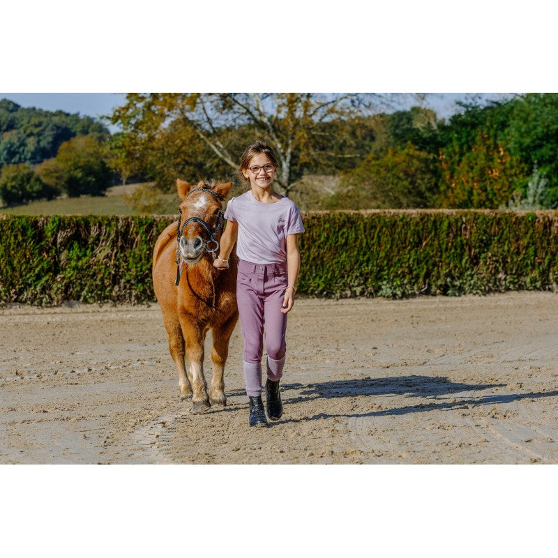 Young girl walking with a pony wearing Carly Junior lilac riding leggings by Equitheme – Ekkivibes