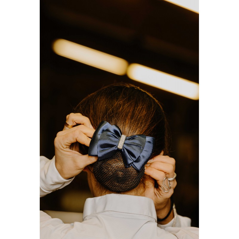 Equitheme Strass navy satin bow hair clip worn on a rider's bun in a stable – equestrian competition hair clip at Ekkivibes