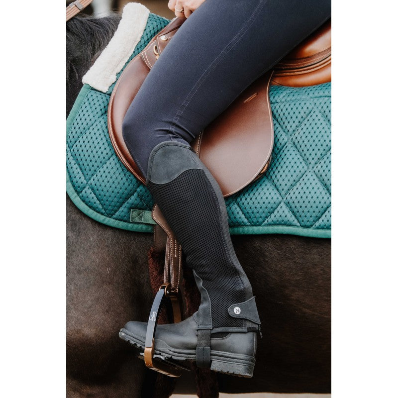 Rider on horseback wearing Norton Airflow black half-chaps – breathable mesh equestrian chaps at Ekkivibes